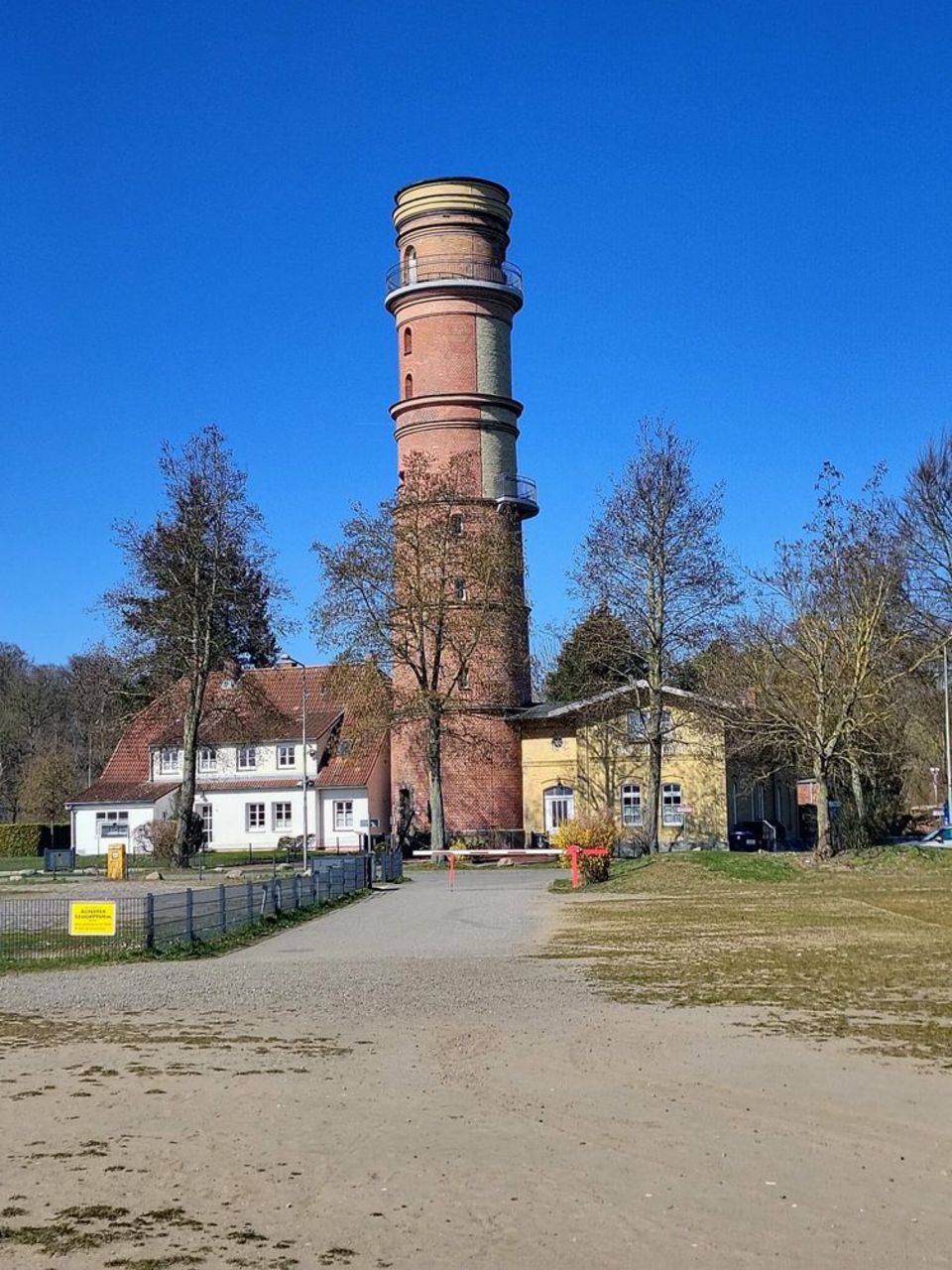Blick auf einen hohen runden Turm aus roten Backsteinen.